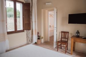 a room with a bed and a desk and a television at Villa Chiara in Villamar