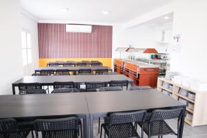 AM Hostel في سليمة: غرفة مع طاولات وكراسي في مطبخ