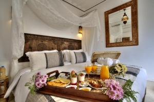 マラケシュにあるRiad Mazarin des gourmetsのホテルルーム ベッドの上に朝食トレイ付