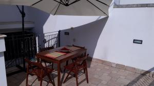 un tavolo con due sedie e un ombrellone di Salento Holiday a Melendugno