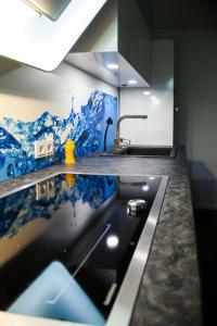 a kitchen with a sink and a counter top with blue tiles at the birdy mountains luxury lodge 146qm, Sauna, Entertainment in Schlitz +29 photos
