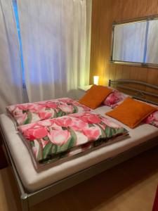 a bed with a pink blanket with roses on it at Flat Speicher St. Gallen in St. Gallen