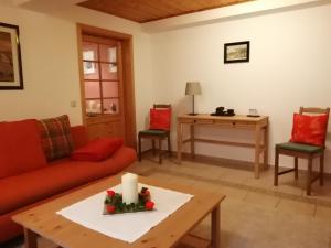 ein Wohnzimmer mit einem roten Sofa und einem Tisch in der Unterkunft Ferienwohnung Ulbrich in Neustadt in Sachsen