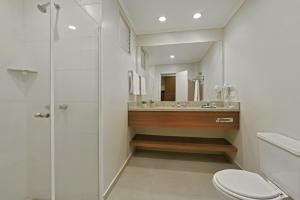 a bathroom with a toilet, sink, and bathtub at Hotel Deville Curitiba Batel in Curitiba