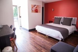 アングレームにあるAppart-hôtel Chanzy / Angoulêmeの赤い壁のベッドルーム1室(大型ベッド1台付)