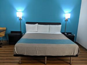 Bett in einem Zimmer mit blauer Wand in der Unterkunft Motel 6 Chattanooga - Airport in Chattanooga