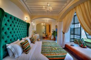 um quarto com uma cama grande e uma cabeceira verde em Riad Saranda Hotel Restaurant & Spa em Marrakech