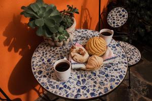 une table avec une assiette de nourriture et deux tasses de café dans l'établissement TIERRA SOÑADA HOTEL BOUTIQUE, à Tepatitlán de Morelos