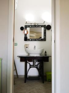 La salle de bains est pourvue d'un lavabo et d'un miroir. dans l'établissement B&B L ORTENSIA, à Bolsena