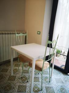 a white table and chairs in a room with a window at B&B L ORTENSIA in Bolsena
