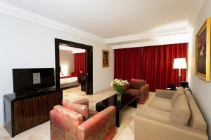 a living room with a couch and a television at Occidental Lac Tunis in Tunis