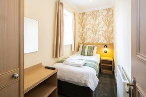 a small bedroom with a bed and a window at Burbage Holiday Lodge Apartment 3 in Blackpool