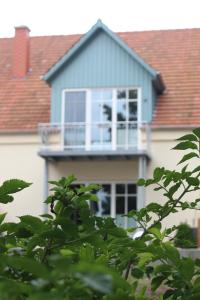 a blue house with a balcony on top of it at De Wümmestuuv in Fischerhude