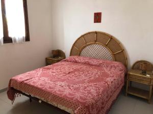 una camera da letto con un grande letto con una coperta rossa di Appartamento Iris 300 mt spiaggia a San Teodoro