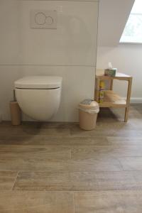 a bathroom with a toilet and a trash can at De Wümmestuuv in Fischerhude