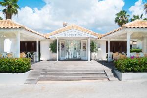 um edifício branco com entrada para um resort em Papagayo Beach Resort em Willemstad