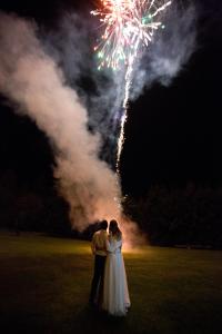 eine Braut und ein Bräutigam stehen auf einem Feld mit Feuerwerk in der Unterkunft Pension Klokočí in Sněžné