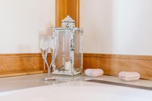 a table with two wine glasses and a clock at Landgasthof und Seminarhotel Lueg in Kaltacker