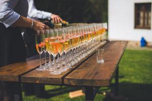 une rangée de verres à vin assis sur une table en bois dans l'établissement Pension Klokočí, à Sněžné