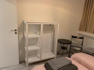 ポルトにあるCity Heart Place 1のベッドの横に白い本棚が備わるベッドルーム