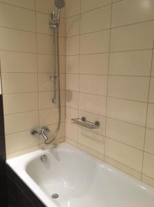y baño con bañera blanca y ducha. en Apartment Medvědín 87, en Špindlerův Mlýn
