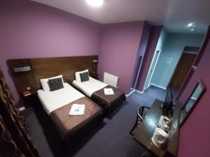 a hotel room with two beds and a television at The Queensberry Hotel in Dumfries