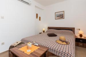a bedroom with a bed with a hat on it at Apartments Green Harmony in Mlini +30 photos