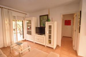 a living room with a tv and a table at Apartamento Jardín del golf 2 in Chiclana de la Frontera