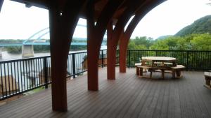 a porch with a picnic table and a bridge at Cobblestone Inn & Suites - Marquette in Marquette