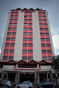 een hoog gebouw met auto's geparkeerd voor het bij São Joaquim Park Hotel in São Joaquim