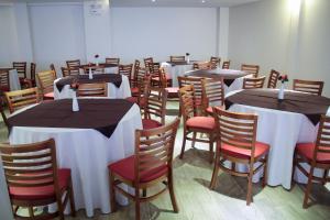 聖若阿金的住宿－São Joaquim Park Hotel，一间设有桌椅和白色桌布的房间