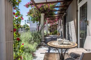 a patio with a table and flowers on a building at Greenlawns B&B in Cape Town