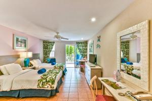 una camera d'albergo con letto e specchio di Butterfly Beach Hotel a Christ Church