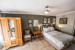Schlafzimmer mit einem Bett, einem Tisch und einem Schreibtisch in der Unterkunft Greenlawns B&B in Kapstadt