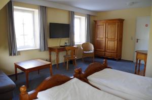 um quarto de hotel com duas camas e uma secretária e uma televisão em Landhaus Nütschau em Bad Oldesloe