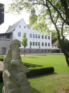 a statue in front of a large white building at Landhaus Nütschau in Bad Oldesloe