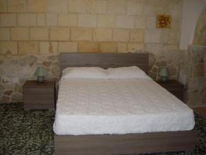 łóżko w sypialni z 2 szafkami nocnymi i 2 lampami w obiekcie La Casetta w mieście Oria