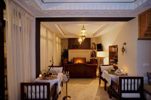 マラケシュにあるRiad Mazarin des gourmetsのテーブル2つとソファのあるリビングルーム