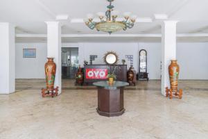 ein großes Zimmer mit einem Tisch und zwei Vasen in der Unterkunft SUPER OYO Collection O 252 Istana Permata Ngagel in Surabaya