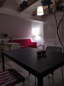 a living room with a table and a red couch at Luxury accommodation near Prague airport in Středokluky