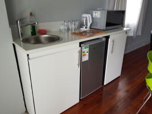 eine kleine Küche mit einer Spüle und einer Mikrowelle in der Unterkunft ARCHITECTs VIEW - SUIT 2 in Durban