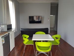 ein Esszimmer mit einem Tisch und grünen Stühlen in der Unterkunft ARCHITECTs VIEW - SUIT 2 in Durban