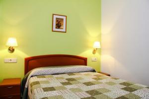 a bedroom with a bed and a lamp at Pensión Numancia in Madrid