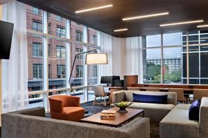 sala de estar con muebles y ventanas grandes. en Hyatt Place Grand Rapids Downtown, en Grand Rapids