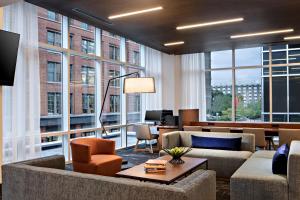 a living room with furniture and large windows at Hyatt Place Grand Rapids Downtown in Grand Rapids