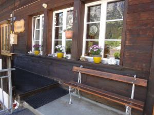 a bench in front of a building with windows at Lehmann's Herberge Hostel in Grindelwald