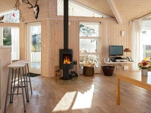 a living room with a fireplace and a table at 6 person holiday home in Knebel in Ørby