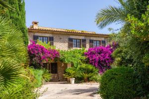 a house with purple flowers in front of it at Villa Can Curt in Pollença