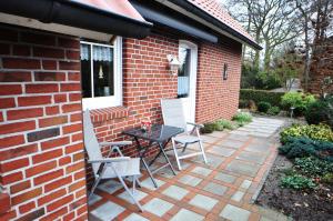 a patio with a table and chairs next to a brick house at Ferienwohnung Anni, 65325 in Moormerland