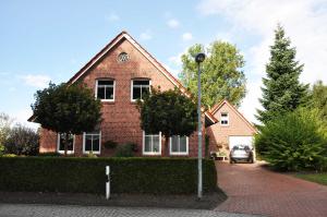a brick house with a car parked in front of it at Ferienwohnung Anni, 65325 in Moormerland